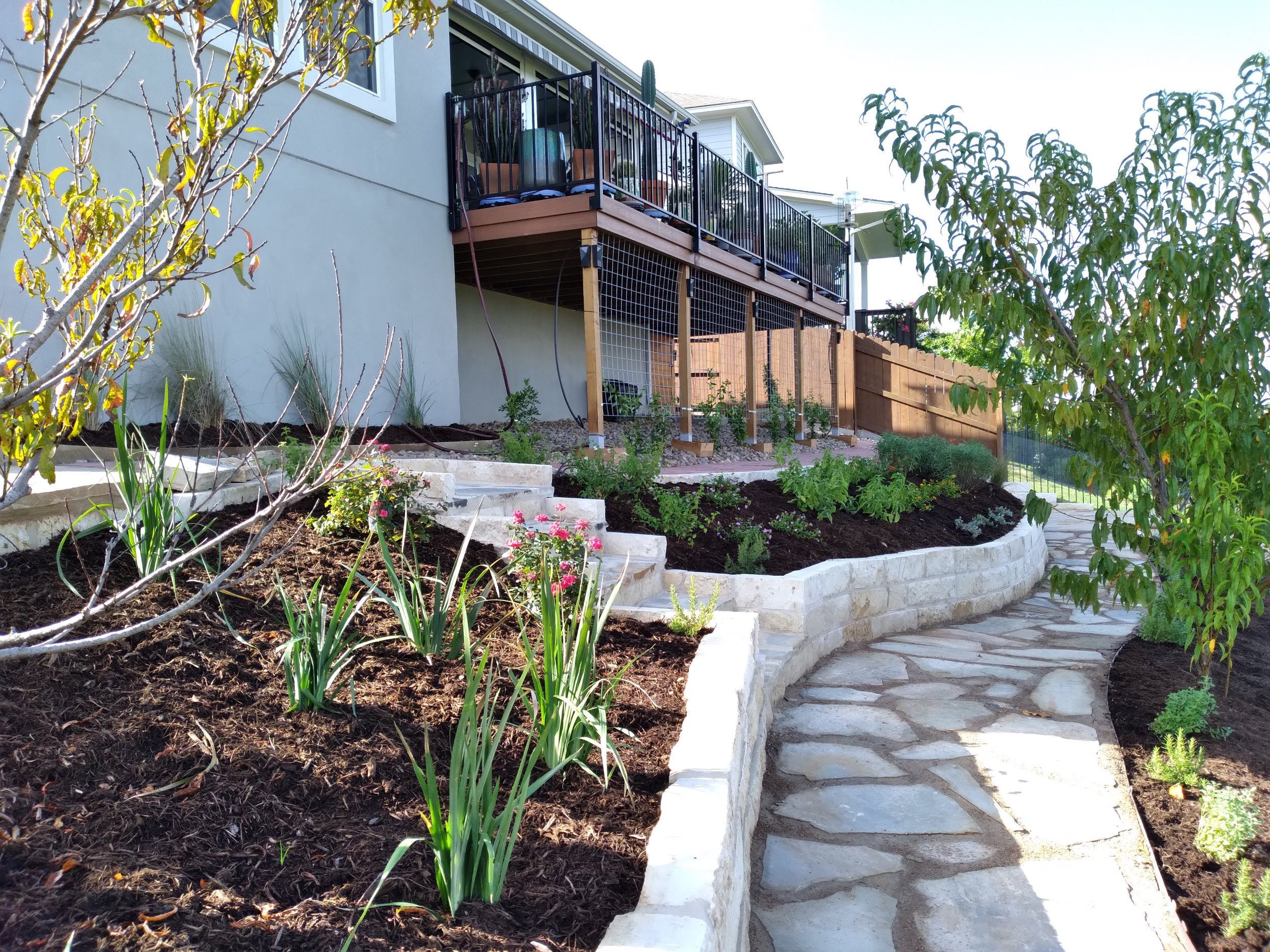 Sloped landscape with stone retaining beds and coordinated grading